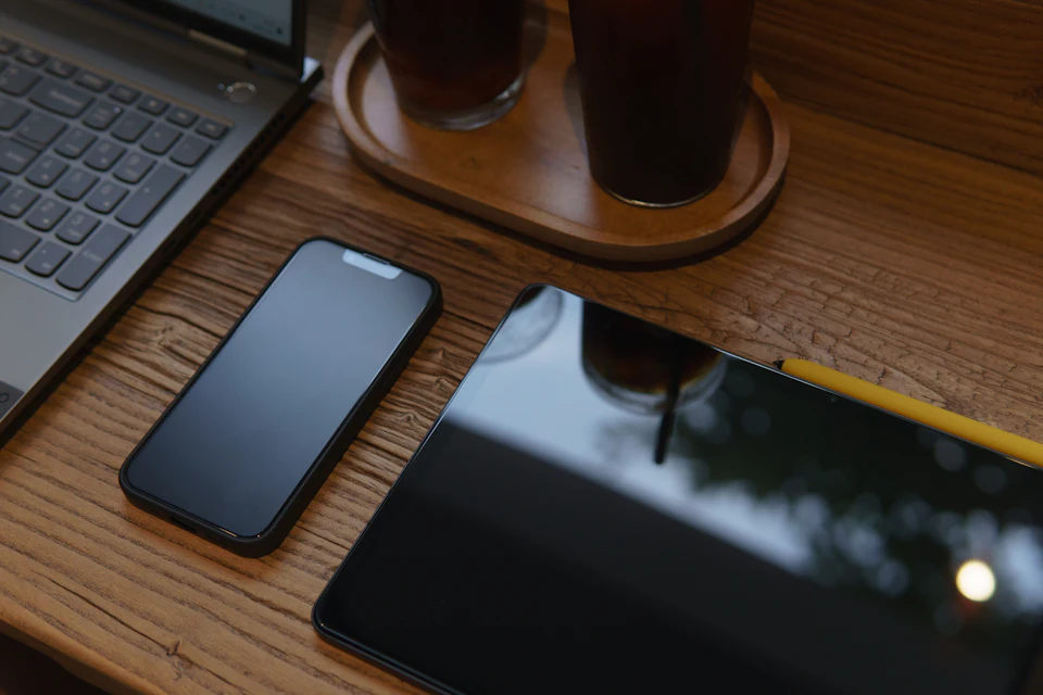 Tablet, smartphone e portatile appoggiati su un tavolo di legno